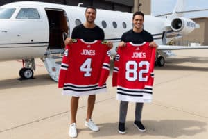 seth and caleb jones taking a picture with chicago blackhawk jerseys